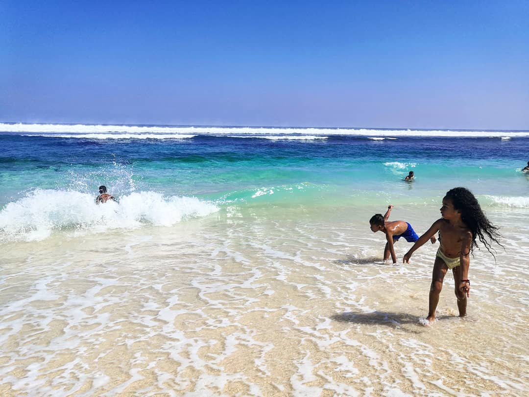 Berenang di pantai melasti